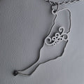 Collar Fuerteventura argolla canaria símbolo 8 espirales necklace with intricate spiral design in silver tone on leather background