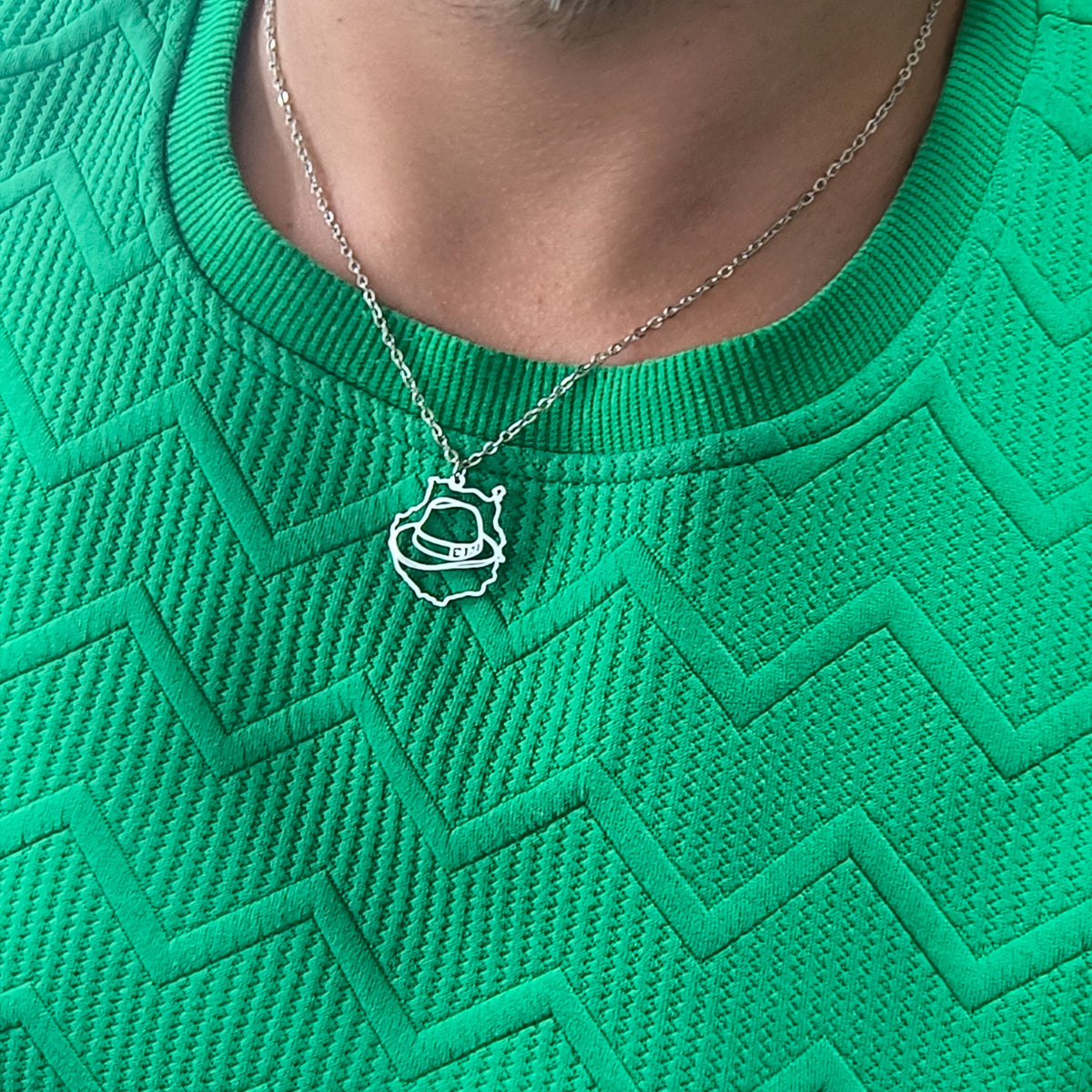 Collar de la isla de Gran Canaria con cachorro canario en acabado plateado, llevado sobre una camiseta