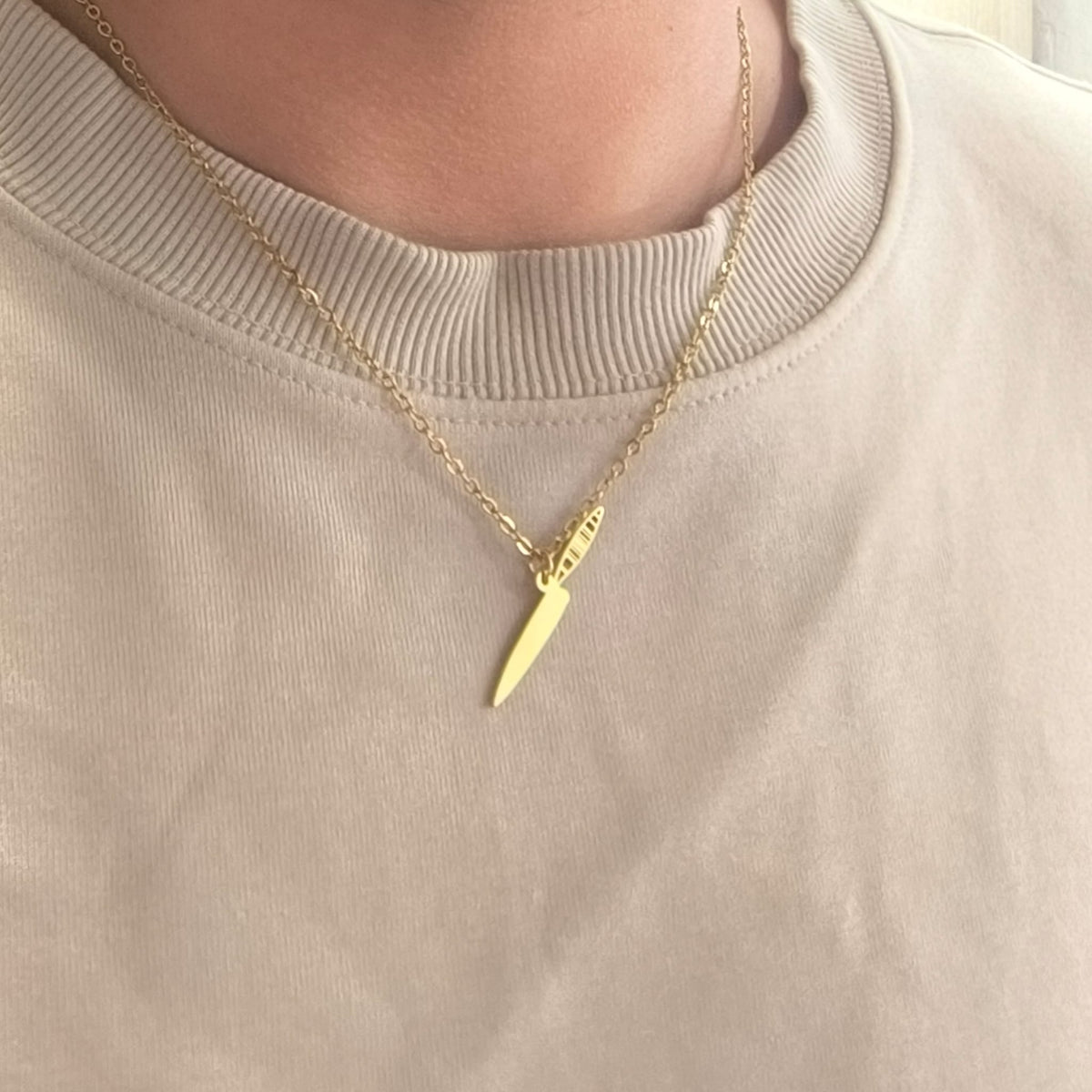 Collar Naife Canario en acabado dorado, llevado sobre una camiseta